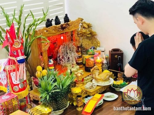 Gia đình thực hiện nghi lễ cúng nhà mới với bàn thờ