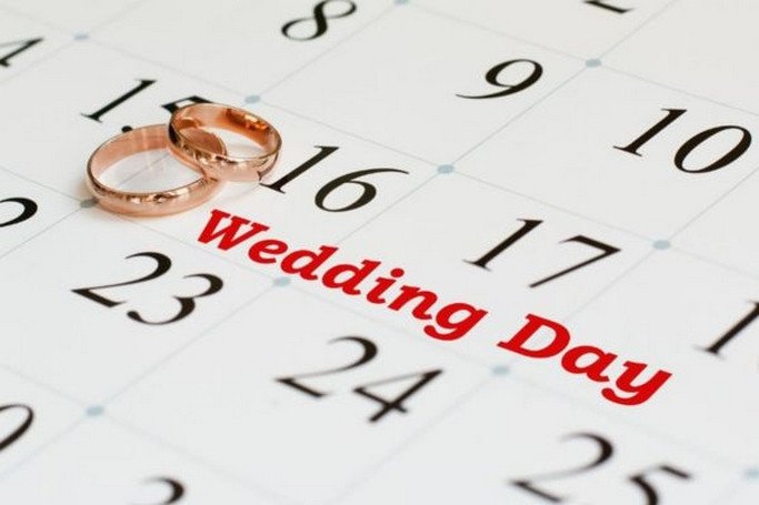 Đôi bạn trẻ đang xem lịch hoặc bàn bạc về ngày giờ cưới đẹp, thể hiện sự quan tâm đến việc chọn thời điểm kết hôn tốt lành