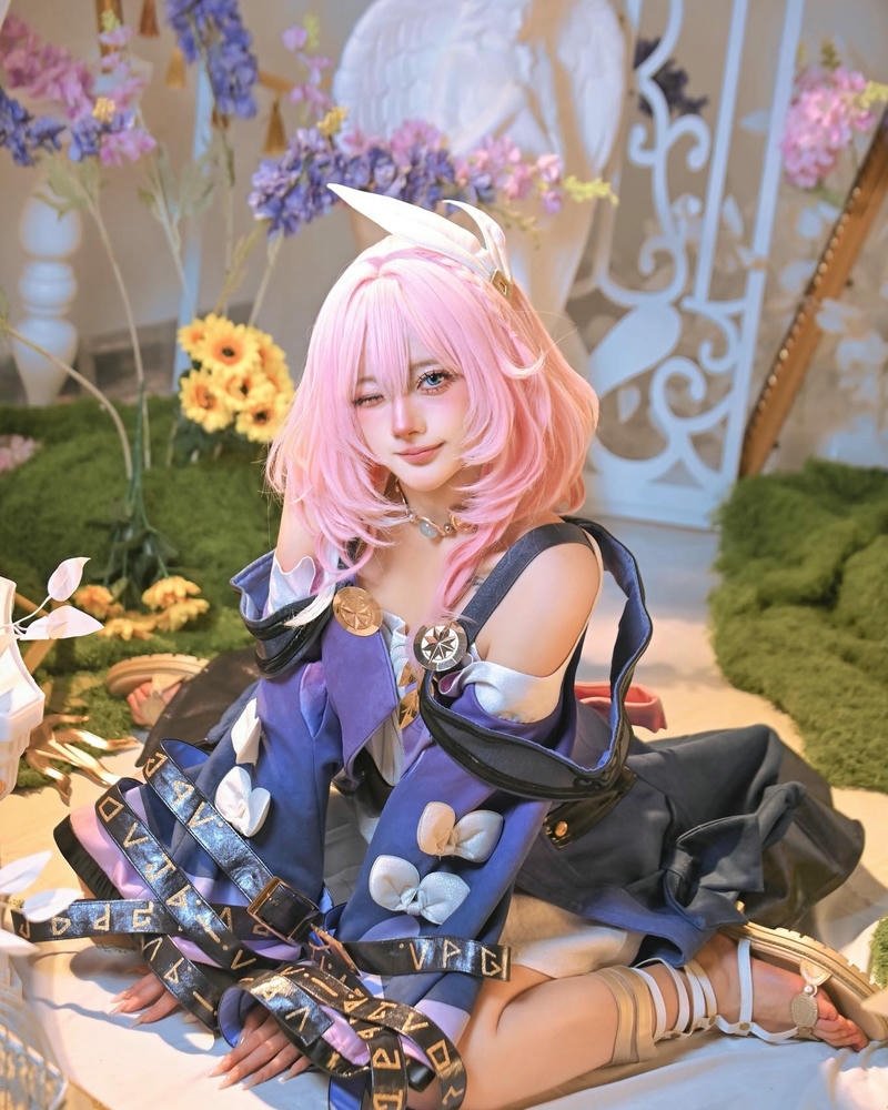 Ảnh cosplay Hà Vi váy xanh ngồi trên ghế gỗ
