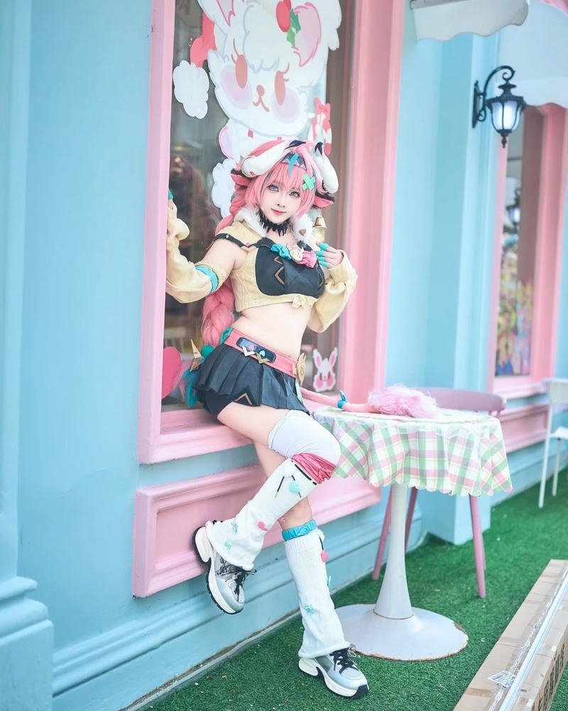 Ảnh cosplay bò sữa váy hồng ngồi trên ghế