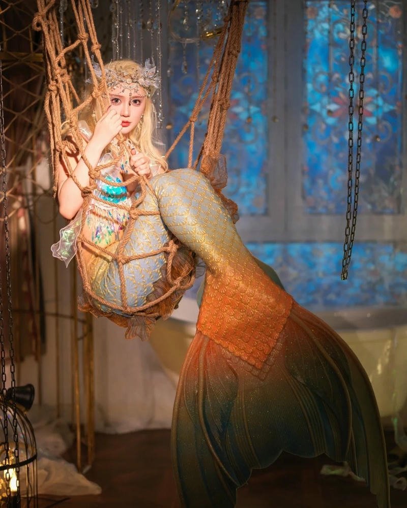 Cosplay nàng tiên cá đuôi cam ngồi trên lưới trắng