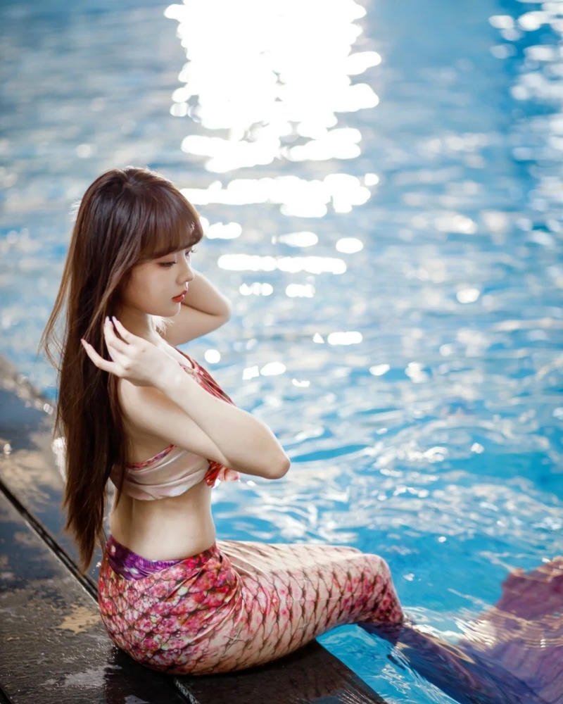 Cosplay nàng tiên cá đuôi đỏ ngồi bên bể bơi