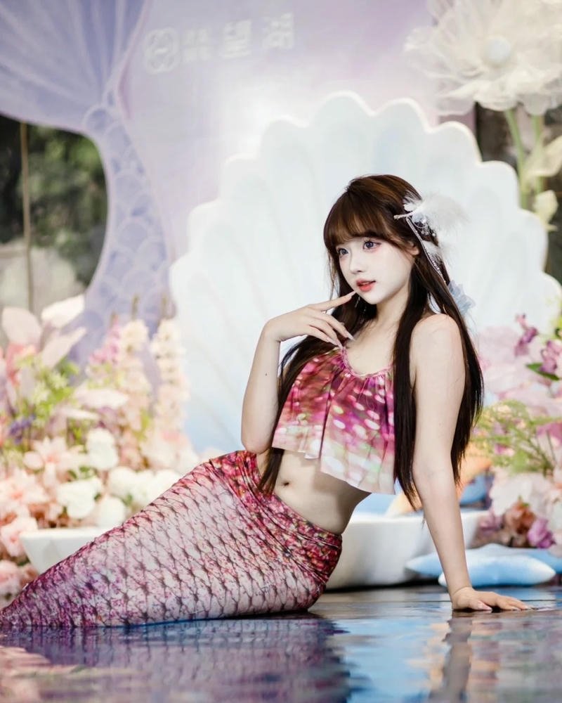 Cosplay nàng tiên cá đuôi hồng ngồi bên hồ nước