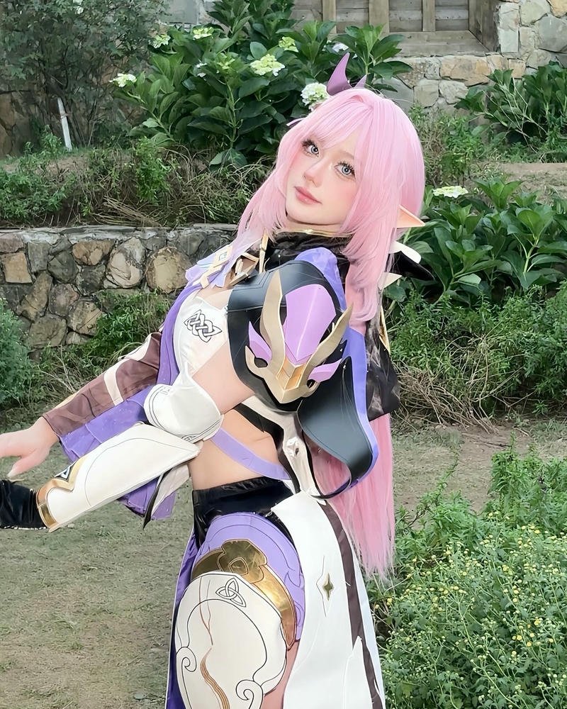 Cosplayer Hà Vi chiến binh hồng đứng giữa thiên nhiên