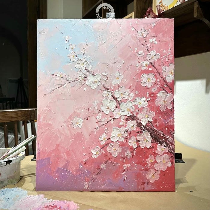 Tranh sơn dầu hoa đào đang vẽ trên giá gỗ