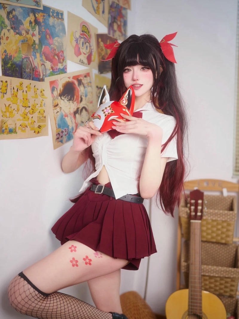 Nữ sinh cosplay đồng phục đỏ ngồi cầm đạo cụ nhỏ