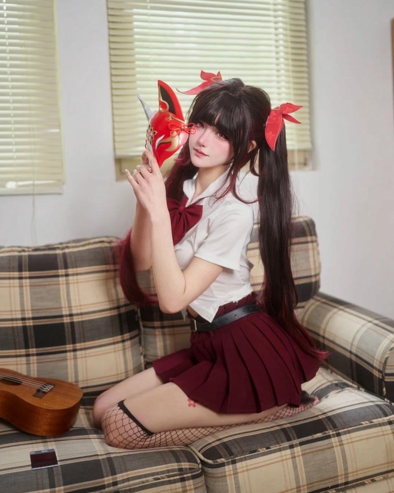Nữ sinh cosplay đồng phục đỏ ngồi trên ghế sofa trắng