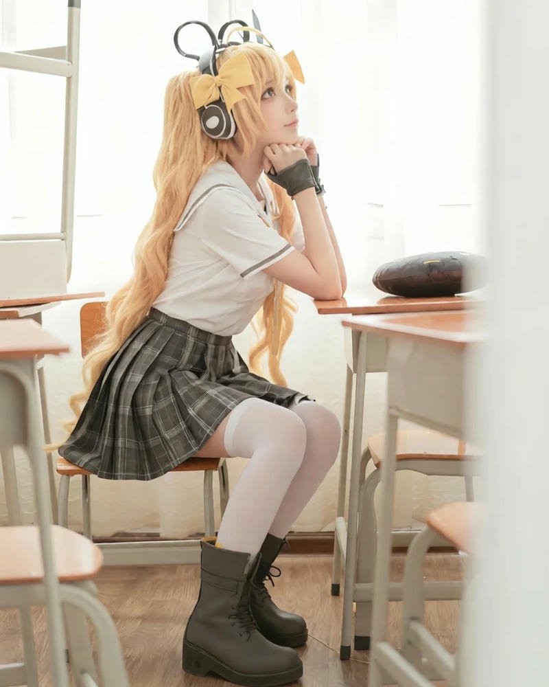 Nữ sinh cosplay đồng phục xám đỏ ngồi trên bàn học