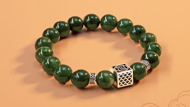 Bộ trang sức ngọc cẩm thạch xanh bao gồm vòng tay, mặt dây chuyền và nhẫn trên nền trắng