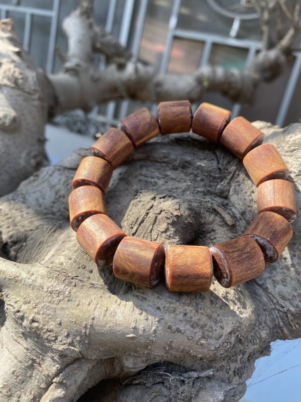 Chiếc vòng tay trúc nhộng làm từ gỗ Hoàng Đàn Tuyết Lạng Sơn, thể hiện vẻ đẹp tự nhiên của gỗ.