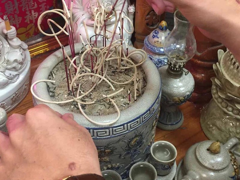 Gia chủ cẩn thận rút chân nhang khỏi bát hương khi bao sái ban thờ