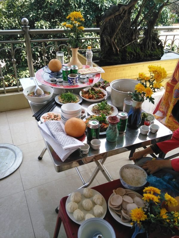 Gia đình chuẩn bị mâm cúng tạ đất tại sân, thể hiện sự trang trọng khi thực hiện nghi lễ cầu may mắn.