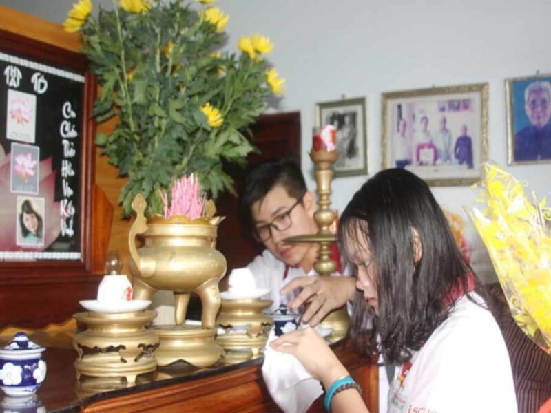 Hình ảnh gia đình đang tỉ mỉ lau dọn ban thờ đón Tết, chuẩn bị cho nghi lễ tiễn ông Công ông Táo.