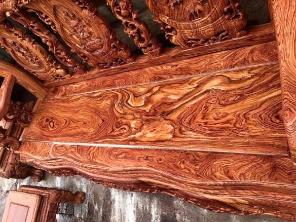 Hình ảnh miếng gỗ hương đá với vân uốn lượn màu đỏ cam