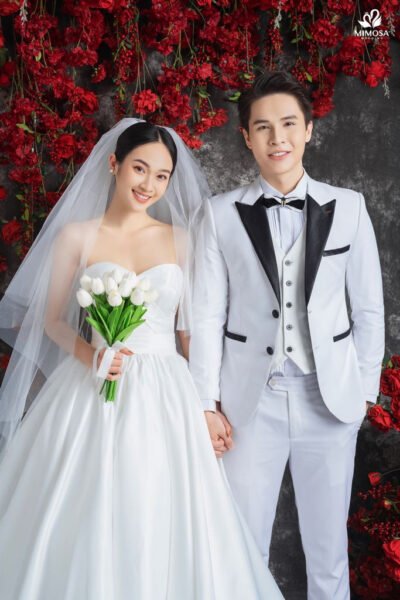 Một đôi uyên ương nắm tay nhau trên bãi biển, biểu tượng cho sự gắn kết và hạnh phúc vĩnh cửu