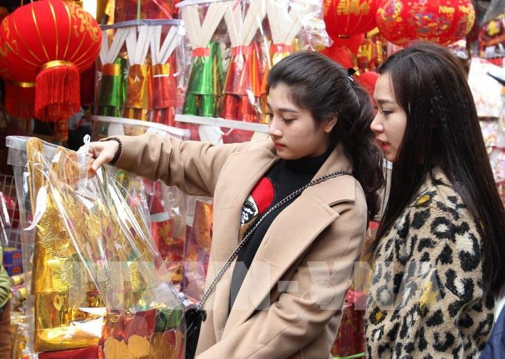 Người dân mua sắm đồ lễ chuẩn bị cho ngày cúng ông Táo về trời trên phố Hàng Mã