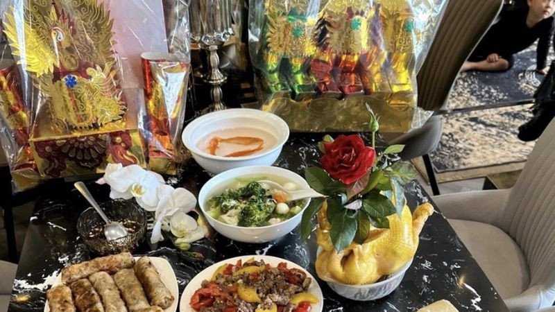 Người phụ nữ đang lau dọn ban thờ cẩn thận, chuẩn bị cúng ông Táo