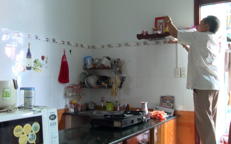Người phụ nữ dọn dẹp bàn thờ Ông Táo sau khi cúng
