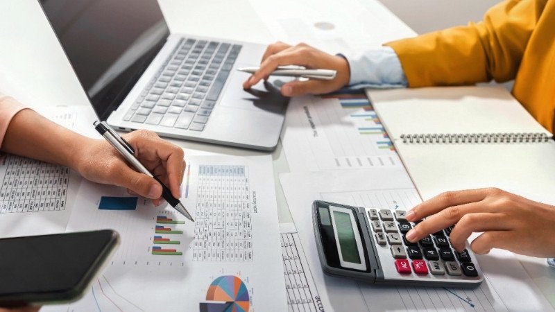 Người phụ nữ làm việc cẩn thận với máy tính và giấy tờ, biểu thị sự tỉ mỉ, phù hợp với công việc kế toán của cung Xử Nữ sinh tháng 8.