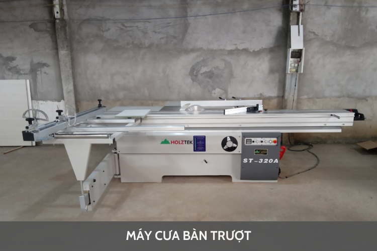 Hình ảnh một người thợ mộc đang cẩn thận sử dụng máy cưa bàn để cắt một tấm gỗ lớn trong xưởng mộc