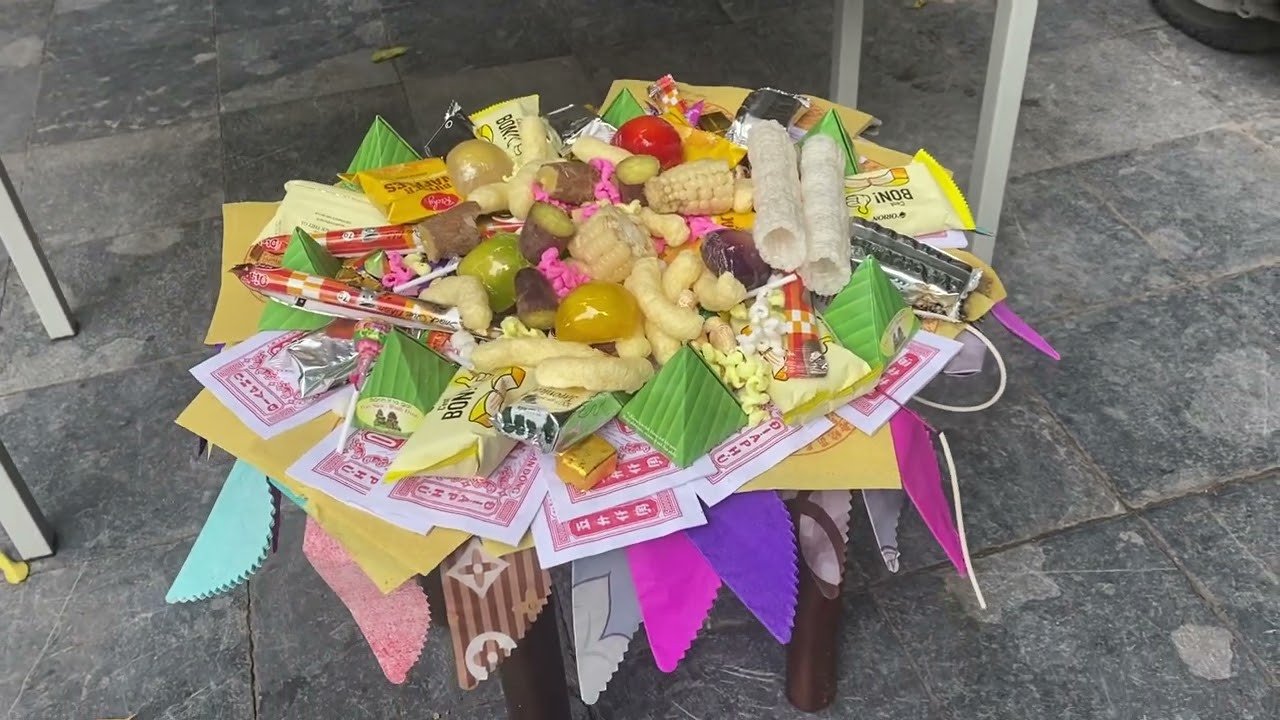 Thực hiện lễ cúng chúng sinh ngoài trời với hương, đèn, và các vật phẩm cúng