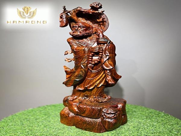 Tượng Đạt Ma đứng với vẻ mặt uy nghiêm, tay cầm Thiền Trượng, thể hiện ý nghĩa trấn trạch trừ tà.